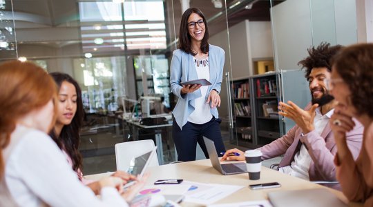 Kvinna håller möte framför grupp
