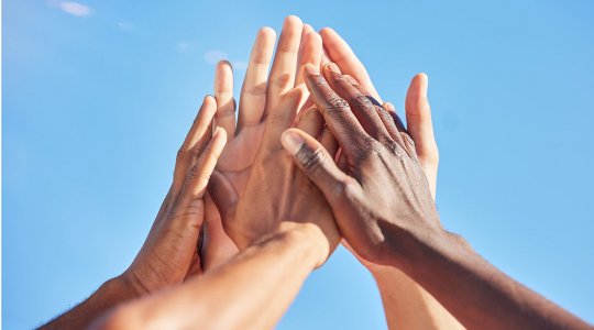 Händer i high five mot himlen