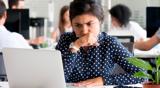 Orolig kvinna tittar in i datorskärmen