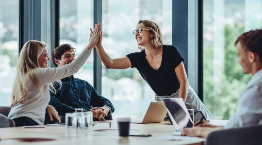 Kvinna ger high-five till en person i en grupp