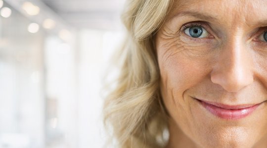 Närbild på kvinna som tittar rakt in i kameran och ser ut att aktivt lyssna på någon.