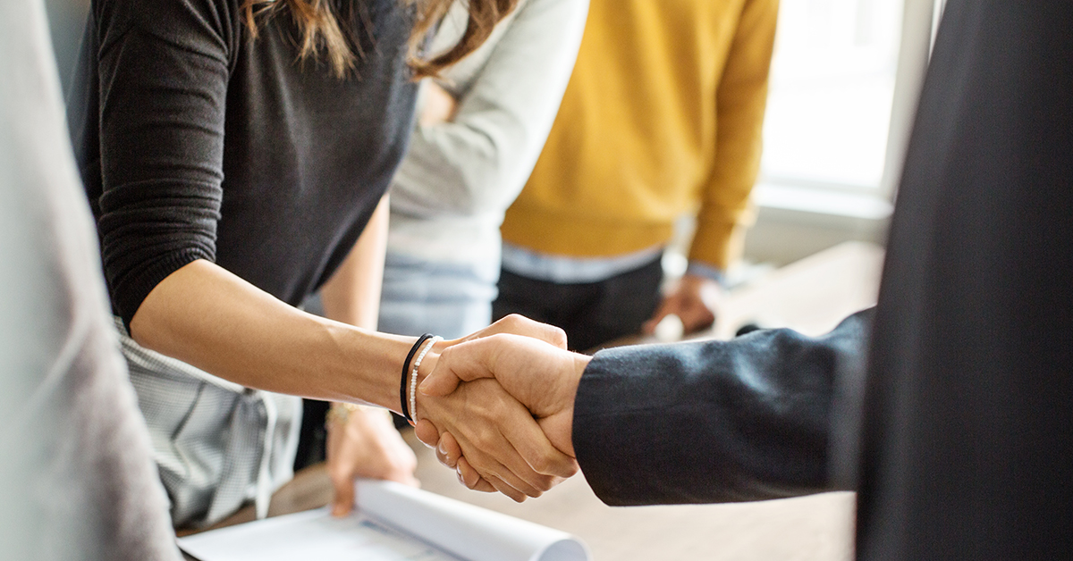 Beskuren bild av två personer som skakar hand vid förhandling – Framfot.