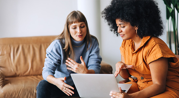 Två kvinnor tittar på en dator