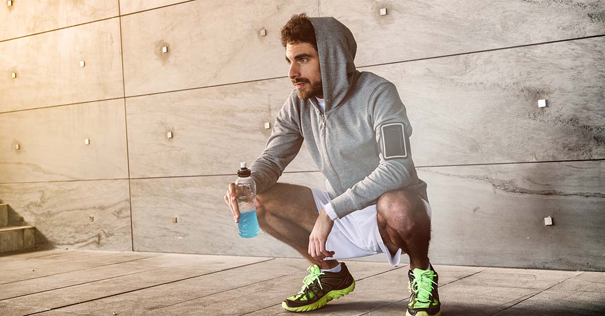 En man med vattenflaska som förbereder sig för ett tufft träningspass