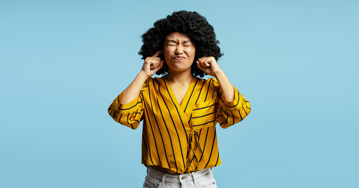 Kvinna som håller för öronen